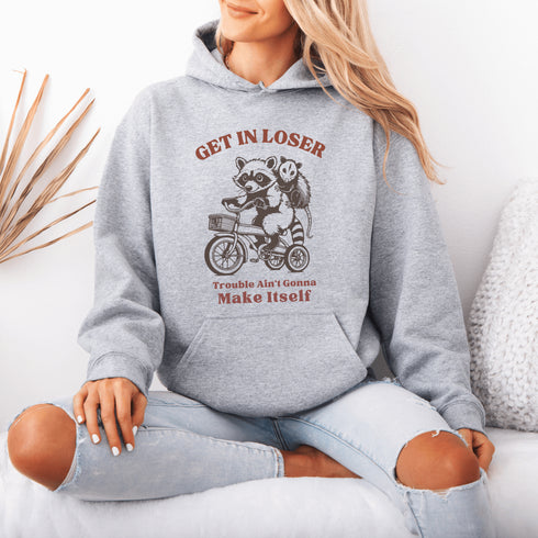 Fuel your wild side with our bold and hilarious hoodie featuring a mischievous raccoon and possum duo cruising on a bike.